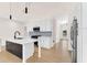 Modern kitchen with a dark kitchen island, white cabinets, and stainless steel appliances at 5862 Harbour Town Dr, Noblesville, IN 46062