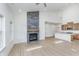 Spacious living room with a large fireplace, light-colored floors, and a kitchen with modern appliances at 5862 Harbour Town Dr, Noblesville, IN 46062