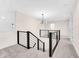 Upstairs landing with modern black railings and chandelier at 5874 Harbour Town Dr, Noblesville, IN 46062