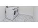 Well-lit laundry room showcasing marble-patterned tile floor and white Samsung washer and dryer at 5874 Harbour Town Dr, Noblesville, IN 46062