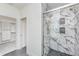 Elegant shower with marble-style tiles, sleek glass doors, and convenient built-in shelving at 5874 Harbour Town Dr, Noblesville, IN 46062