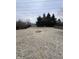 Large backyard with a fire pit area, enclosed with a wood fence, and mature trees at 6533 Parker Ln, Indianapolis, IN 46220