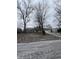 A single-Gathering home with mature trees in the front yard on an overcast day at 6533 Parker Ln, Indianapolis, IN 46220