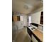 Shows kitchen with white cabinets, vintage appliances, and a view to another room. Requires renovation at 6533 Parker Ln, Indianapolis, IN 46220