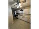 Shows a kitchen design with white cabinets, vintage appliances, and a ceiling fan. Requires renovation at 6533 Parker Ln, Indianapolis, IN 46220