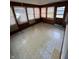 Spacious sun room featuring wood paneling, tile flooring, and natural light from windows, needs TLC at 6533 Parker Ln, Indianapolis, IN 46220