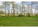A view of the home's backyard featuring green grass and a tree line at 7188 Covington St, Lebanon, IN 46052