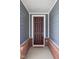 Close-up of a classic front door with brick accents, providing a welcoming entrance at 7188 Covington St, Lebanon, IN 46052