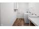 Functional laundry room featuring a washer, dryer, sink, and storage shelving at 7188 Covington St, Lebanon, IN 46052