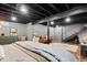 Finished basement showcasing an open ceiling, brick wall accents, and modern finishes at 7643 Dean Rd, Indianapolis, IN 46240