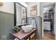 Stylish powder room with modern sink, wood shelf, decorative mirror and laundry access at 7643 Dean Rd, Indianapolis, IN 46240