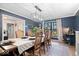Charming dining room with stylish lighting, blue walls, and a view to the outdoors at 7643 Dean Rd, Indianapolis, IN 46240