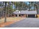 Expansive view of a home's exterior showcasing a long driveway and lush, mature trees surrounding the property at 7643 Dean Rd, Indianapolis, IN 46240