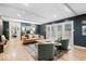 Stylish living room featuring dark walls, wood floors, white trim, and modern furniture with ample natural light at 7643 Dean Rd, Indianapolis, IN 46240
