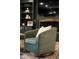 Close up of a teal armchair in the living room with a fireplace and built in shelves behind it at 7643 Dean Rd, Indianapolis, IN 46240