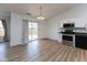 Open-concept dining area with sliding glass doors to the backyard, wood floors, and modern lighting at 8091 Crumwell Dr, Avon, IN 46123