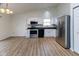 Modern kitchen with stainless steel appliances, granite countertops, white cabinets, and wood-style flooring at 8091 Crumwell Dr, Avon, IN 46123