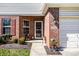 Inviting brick entrance with a storm door, neat landscaping, and an attached garage at 10246 Eller Creek Dr, Fishers, IN 46038