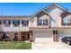 Charming townhome with a well-manicured lawn, two-car garage, and red shutters on the windows at 10246 Eller Creek Dr, Fishers, IN 46038