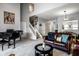 Open-concept living room showcasing a grand piano and stairs leading to the second floor at 10246 Eller Creek Dr, Fishers, IN 46038