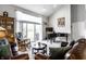 Bright living room featuring a piano, a brown leather sofa, and access to the outdoors at 10246 Eller Creek Dr, Fishers, IN 46038