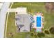 Aerial view of home featuring a blue-covered rectangular pool, hot tub, and patio furniture in a well-manicured lawn at 1032 Westview Point Dr, Columbus, IN 47201