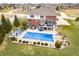 Aerial view highlighting an inground pool with cover, patio area, hot tub, manicured landscaping, and brick home at 1032 Westview Point Dr, Columbus, IN 47201