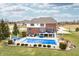 Aerial view featuring a covered rectangular pool, multiple patio areas, and lush green backyard of the brick home at 1032 Westview Point Dr, Columbus, IN 47201
