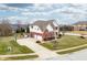 Aerial showcasing a brick and siding home with a three-car garage and well-manicured front lawn at 1032 Westview Point Dr, Columbus, IN 47201