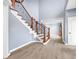 Elegant staircase featuring hardwood steps, wrought iron railings, and a light blue wall color at 1032 Westview Point Dr, Columbus, IN 47201