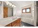 Well-lit bathroom featuring a vanity with sink, a tub, and a framed window at 1086 Pebble Brook Dr, Noblesville, IN 46062