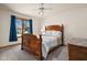 Bright bedroom with a large window, ceiling fan, and a comfortable wooden bed at 1086 Pebble Brook Dr, Noblesville, IN 46062