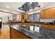 Modern kitchen with a cooktop island, granite countertops, and wood cabinets at 1086 Pebble Brook Dr, Noblesville, IN 46062