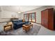 Cozy living room features a large, plush blue couch, wood table, and door to the backyard at 1086 Pebble Brook Dr, Noblesville, IN 46062