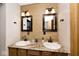 Bathroom with a granite countertop, double sinks, stylish fixtures, and decorative wood plank wall at 12064 N Glena Pl, Mooresville, IN 46158
