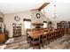 A large dining room table and chairs, a brick fireplace and wood-look floors create a warm gathering space at 12064 N Glena Pl, Mooresville, IN 46158