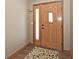 Elegant wooden front door with glass panels, showcasing a glimpse of the interior and a welcoming rug at 12064 N Glena Pl, Mooresville, IN 46158