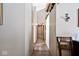 Hallway with rustic floors and neutral walls, leading to various rooms within the home, and a decorative wall sconce at 12064 N Glena Pl, Mooresville, IN 46158