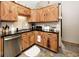 Stylish kitchen with custom wooden cabinets, a stainless steel sink, black countertop, and decorative accents at 12064 N Glena Pl, Mooresville, IN 46158