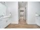 Bright bathroom featuring double vanity, wood flooring, and access to the bedroom at 15 W Executive Dr # 104, Carmel, IN 46032