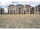 Exterior elevation showcasing a modern brick apartment building with balconies and beautiful landscaping and pedestrian walking paths at 15 W Executive Dr # 104, Carmel, IN 46032