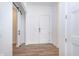 Modern foyer features vinyl plank flooring, white walls, and sliding barn door at 15 W Executive Dr # 104, Carmel, IN 46032