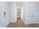 Hallway features vinyl plank flooring, white walls, and multiple white doors at 15 W Executive Dr # 104, Carmel, IN 46032