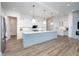 Open kitchen boasts stainless appliances, an island, and white cabinets, with views to a gray shiplap accent wall at 15 W Executive Dr # 104, Carmel, IN 46032