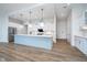 Large open concept kitchen with an eat-in island, stainless steel appliances, and white and blue cabinetry at 15 W Executive Dr # 104, Carmel, IN 46032