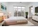 A luxurious main bedroom with large window, balcony access, and plush, neutral-toned bedding on top of a white rug at 15 W Executive Dr # 104, Carmel, IN 46032