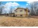 Spacious backyard of yellow house, with a blend of bare trees, sky, and grass at 1852 W 62Nd St, Indianapolis, IN 46260