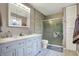 Elegant bathroom featuring double vanity, tiled walls, glass enclosed shower and convenient built-in cabinet at 1852 W 62Nd St, Indianapolis, IN 46260