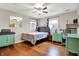 Bright bedroom with hardwood floors, two windows, ceiling fan and comfortable bed with matching furniture at 1852 W 62Nd St, Indianapolis, IN 46260