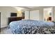 Cozy bedroom with dark wood floors, a black and white floral bedspread, and a TV on a wooden dresser at 1852 W 62Nd St, Indianapolis, IN 46260